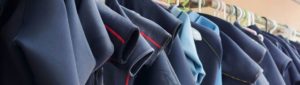 wetsuits hanging and drying in the sun