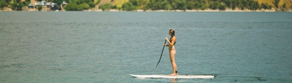 mujer practicando paddle surf en la naturaleza